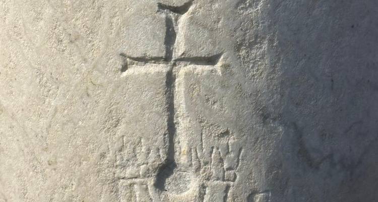 Sculpture sur pierre avec croix et inscriptions.