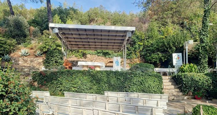 Autel extérieur entouré de verdure avec des chaises dans un cadre en plein air.
