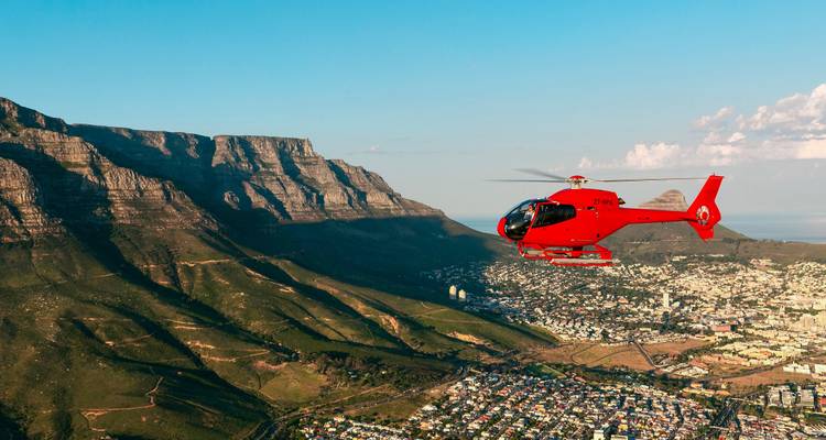 Vue aérienne d'une ville avec des montagnes et un hélicoptère.
