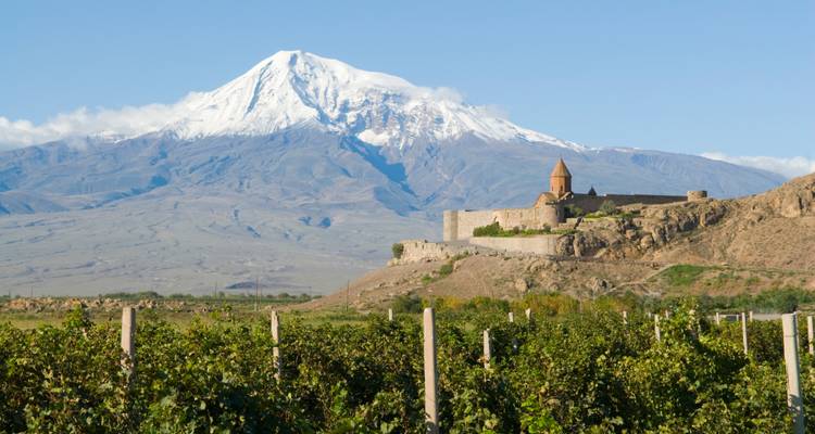 Le monastère de Khor Virap situé devant le Mont Ararat aux sommets enneigés s'élevant au-dessus des vignobles verdoyants