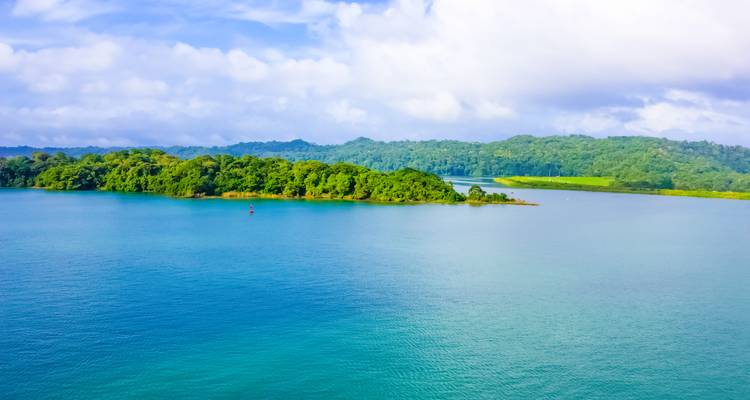 Vista panorámica de una isla verde y exuberante rodeada de agua azul.