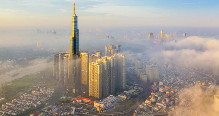High-rise building towering over a cityscape covered in morning fog.
