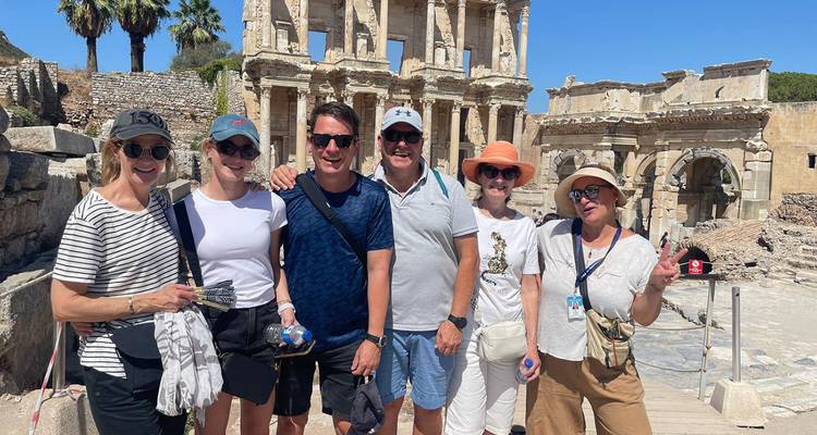 Grupo de turistas posando frente a ruinas antiguas.