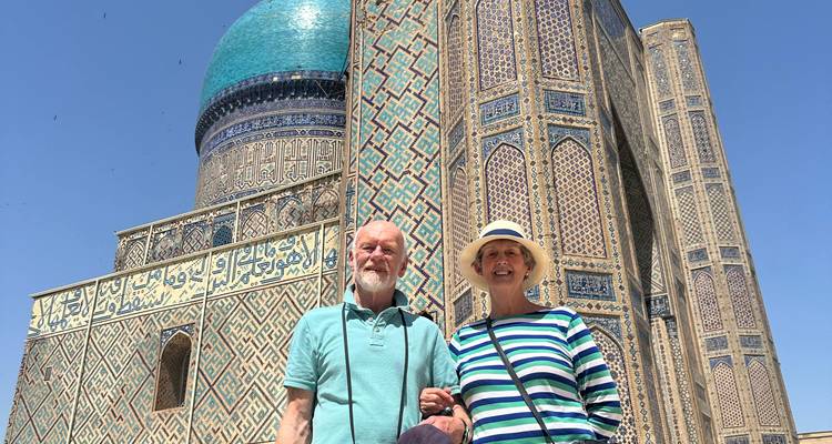Ouder echtpaar staat voor een prachtige blauwtegels dome en minaret.