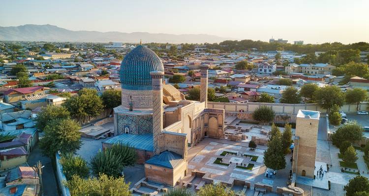 Dronefoto van het Gur-e-Amir mausoleum en de omringende stad badbad in warm zonsondergangslicht.
