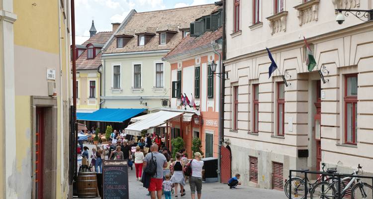 Vue de rue avec des bâtiments colorés et des gens qui marchent.