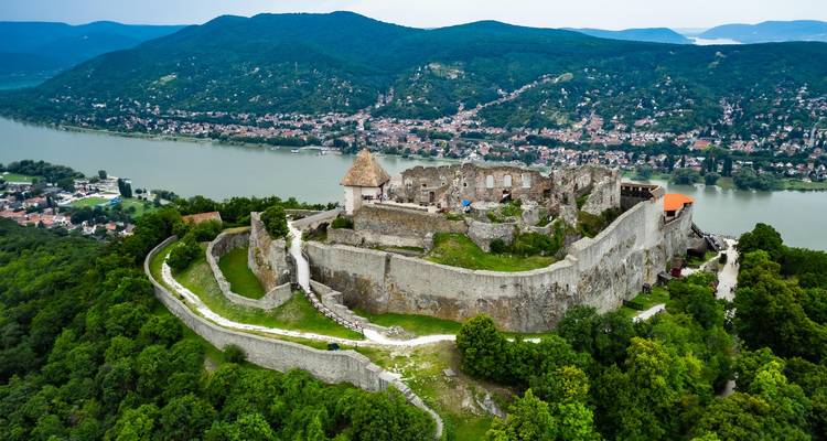 Vista de dron del Castillo de Visegrad encaramado sobre la curva del Danubio y las colinas boscosas.