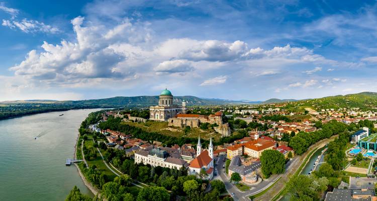 Vista panorámica aérea de la Basílica de Esztergom dominando la ciudad ribereña bajo nubes dramáticas.