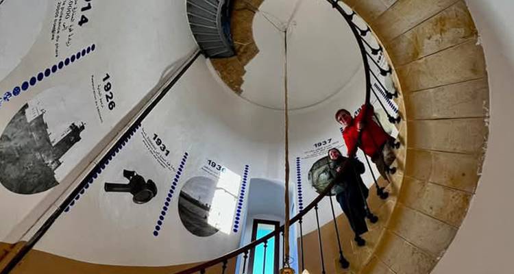 Menschen in einer Wendeltreppe mit historischen Ausstellungsstücken.