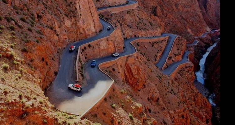 Vue aérienne d'une route sinueuse dans un terrain rocheux.