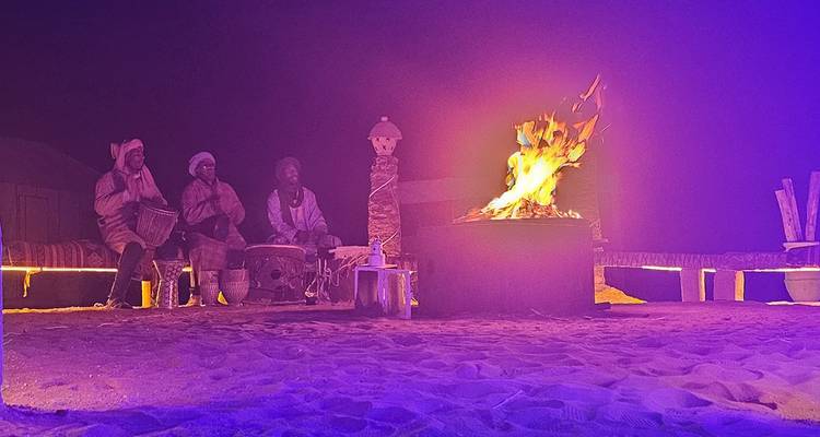 Escena nocturna de fogata con músicos tradicionales.