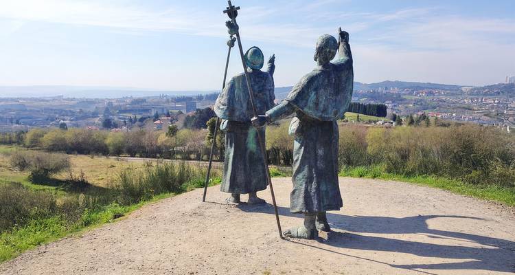 Statue of two pilgrims overlooking a landscape.