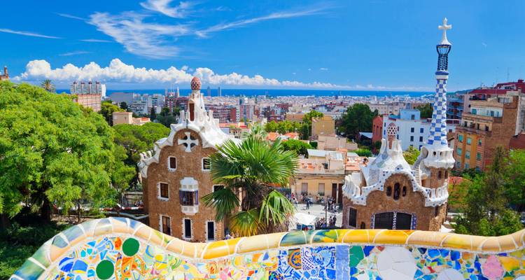 View from Park Güell overlooking colorful buildings and cityscape.