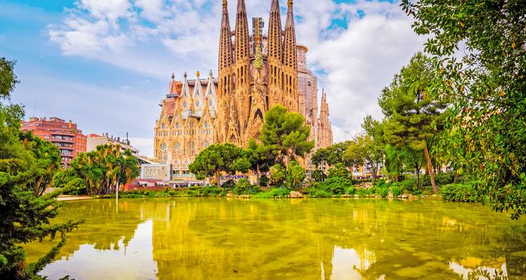 The Sagrada Familia Cathedral reflecting on a pond in Barcelona.