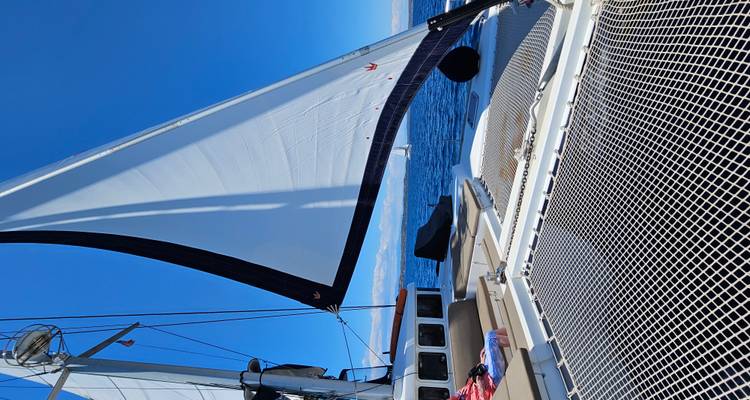 Un yacht avec les voiles déployées par une journée ensoleillée en mer.