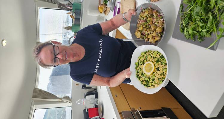 Personne tenant deux bols de nourriture préparée à l'intérieur d'un yacht.