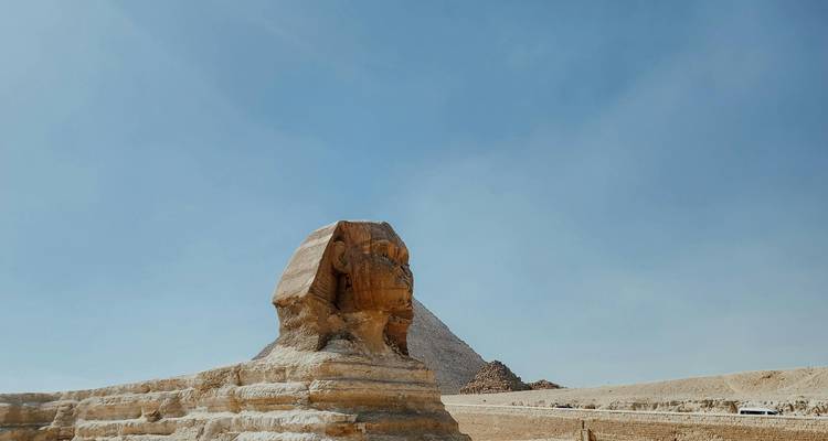 Le Sphinx avec une pyramide en arrière-plan sous un ciel dégagé.