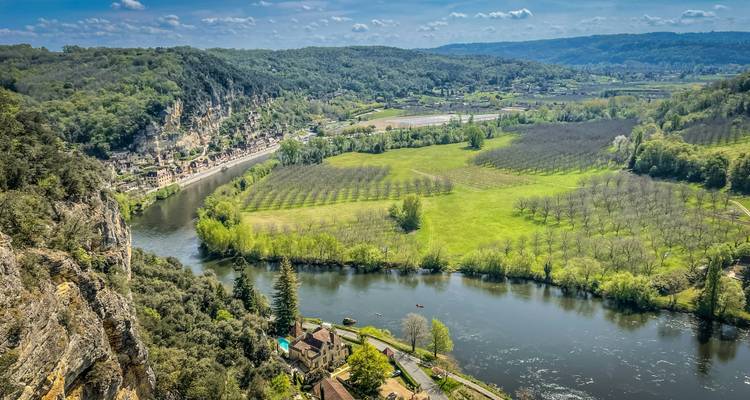 Luftaufnahme eines Flusses mit üppigem Grün und Klippen.