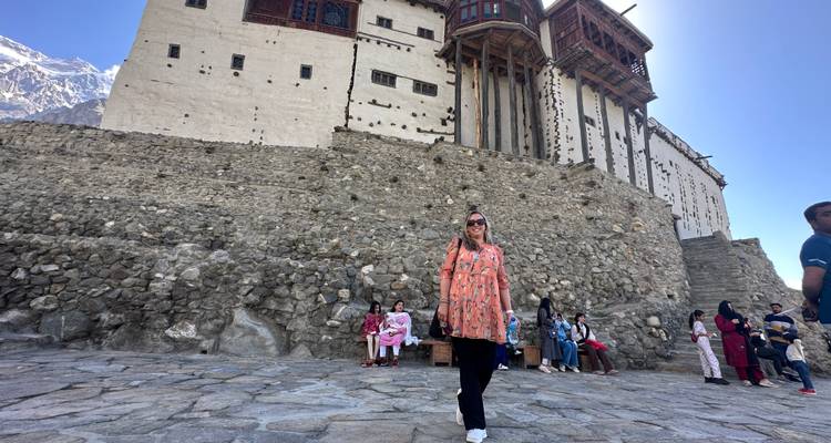 Les touristes se sont rassemblés devant les murs en pierre du fort historique de Baltit