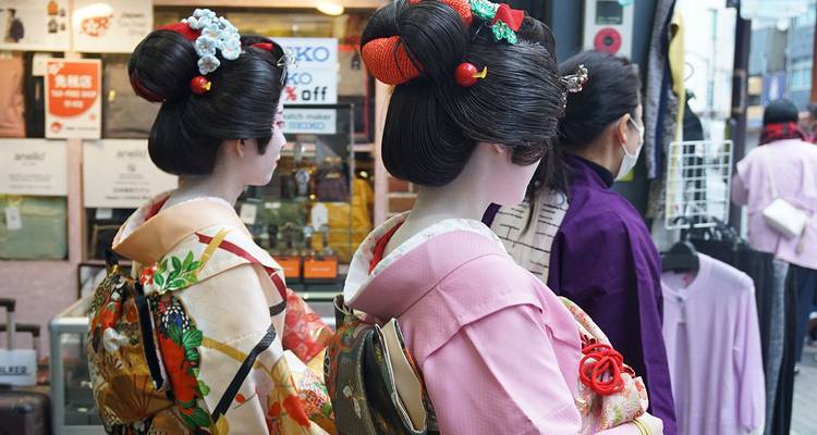 Femmes portant des kimonos traditionnels avec des décorations florales dans leurs cheveux.