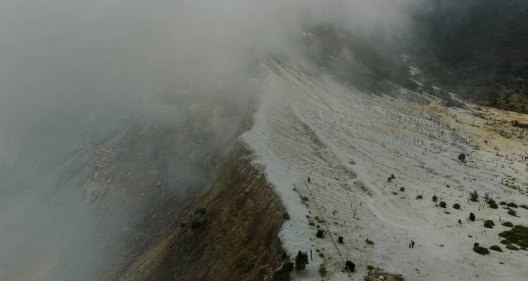 Vista aérea de un paisaje volcánico cubierto de nubes.