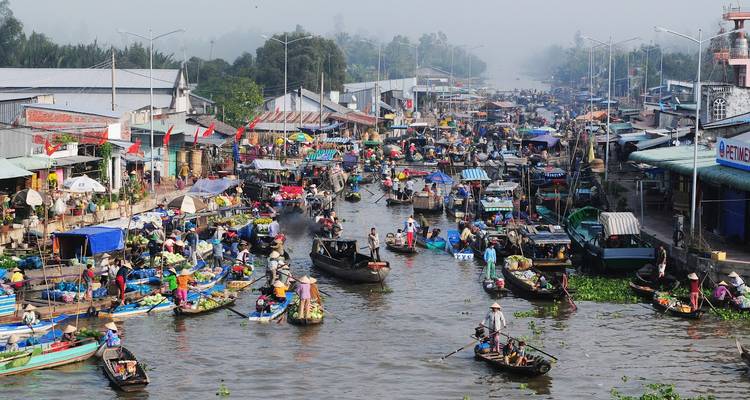 Drukke drijvende markt met talloze boten en mensen.