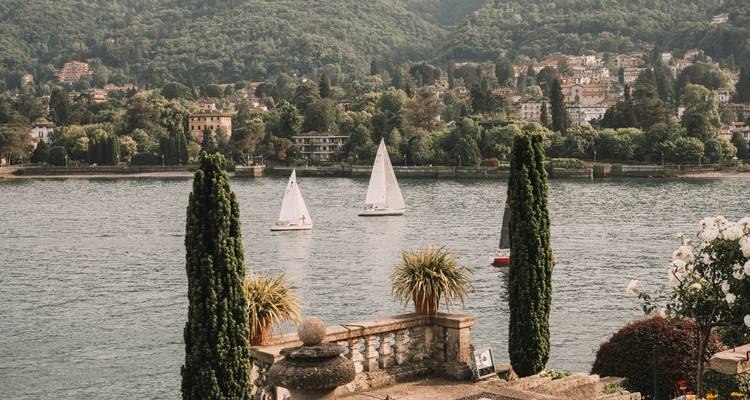 Deux voiliers sur un lac serein avec une végétation luxuriante.