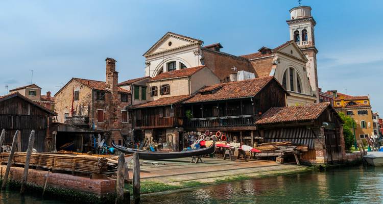 Canal vénitien avec atelier de gondoles et quais en bois.