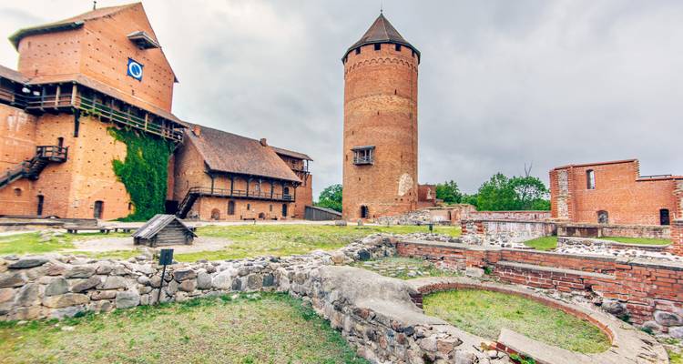 Château historique en brique rouge avec tours.