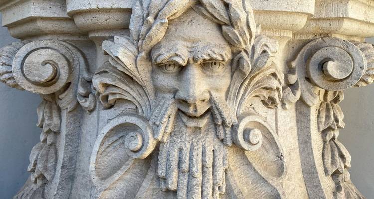 Una talla detallada en piedra de un rostro en decoración arquitectónica.