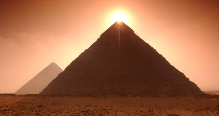 Pyramides capturées au coucher du soleil avec un ciel dramatique.
