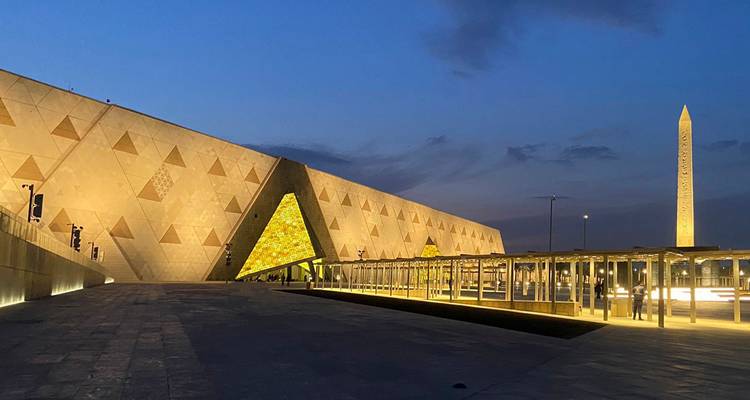 Un musée moderne avec des motifs triangulaires éclairés la nuit.