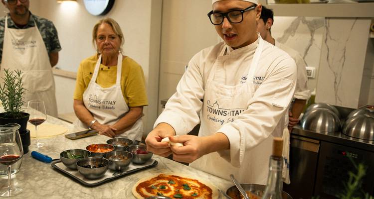Chef présentant une pizza dans un cours de cuisine.