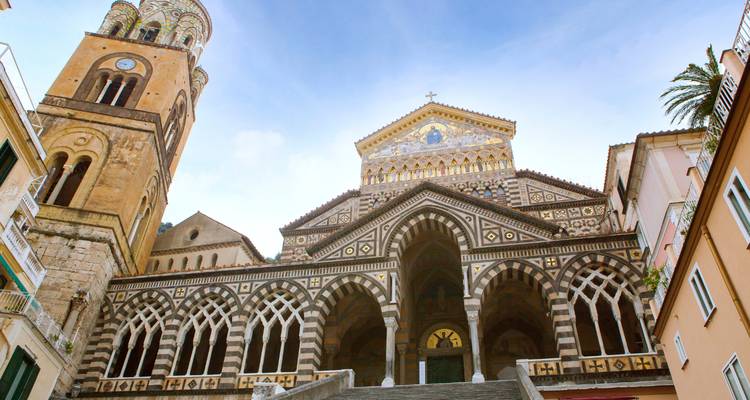Cathédrale ornée avec arcs rayés et clocher.
