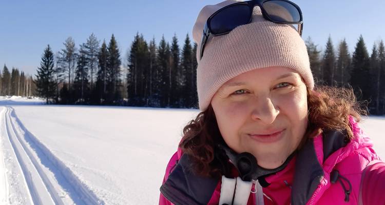 Person, die in einer verschneiten Landschaft posiert und Winterkleidung trägt.