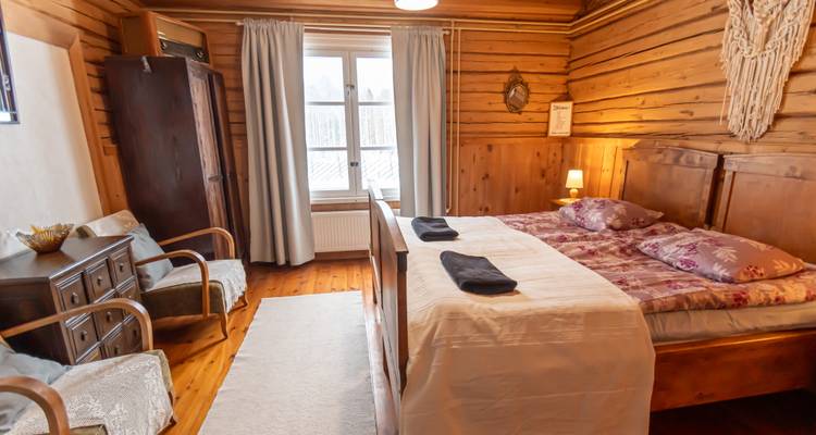 Interieur eines gemütlichen Holzzimmers mit einem Bett und Sitzgelegenheiten.