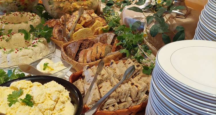 Vielfalt an Speisen auf einem Tisch mit Gerichten und Broten ausgestellt.