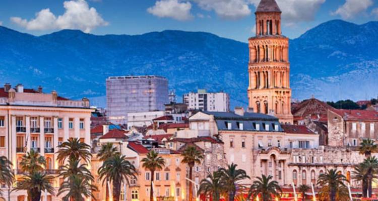 Blick auf die historische Stadt mit Kathedrale und Bergen im Hintergrund.