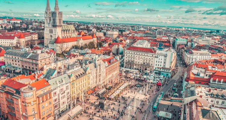 Luftaufnahme von Zagreb mit einer markanten Kathedrale und geschäftigem Stadtleben.