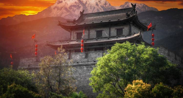 Oud Chinees gebouw met rode lantaarns tijdens zonsondergang.
