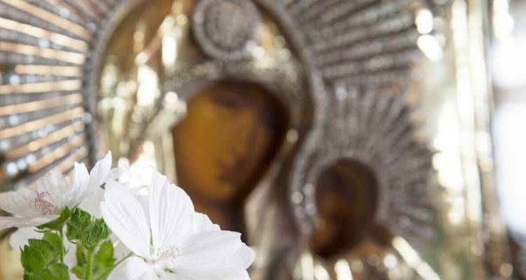 Image floue de fleurs et d'œuvres d'art religieuses.