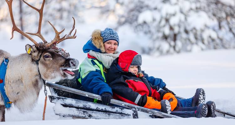 Mère et enfant profitant d'une promenade en traîneau à rennes dans la neige.