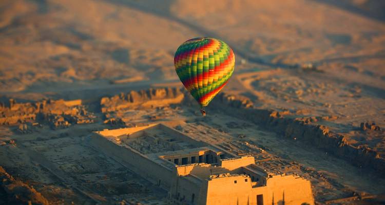 Heißluftballon schwebt über antiken ägyptischen Ruinen.