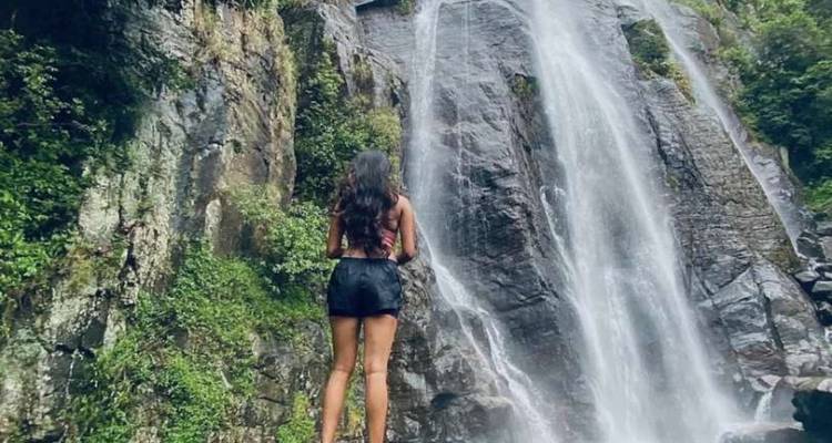 Personne debout devant une cascade.