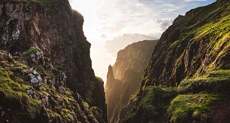 Vue spectaculaire de falaises avec la lumière du soleil illuminant la vallée en contrebas.