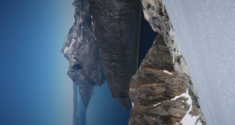 Sommets montagneux enneigés surplombant un fjord.