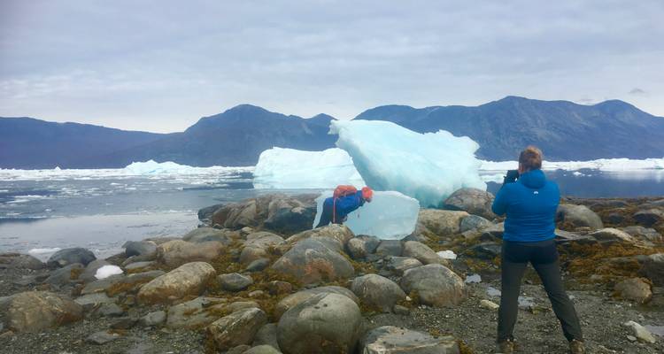 Personne photographiant des formations de glace au bord de l'eau.