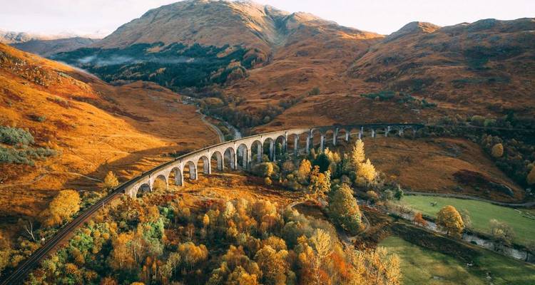 Un viaduc pittoresque dans une vallée luxuriante aux couleurs d'automne.