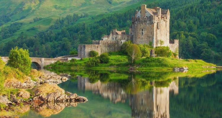 Un château médiéval au bord des eaux calmes d'un loch.