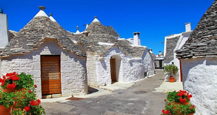 Traditional trulli houses with conical roofs on a bright day.